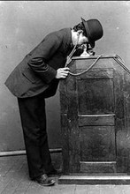 Man looking into the peephole of a kinetoscope